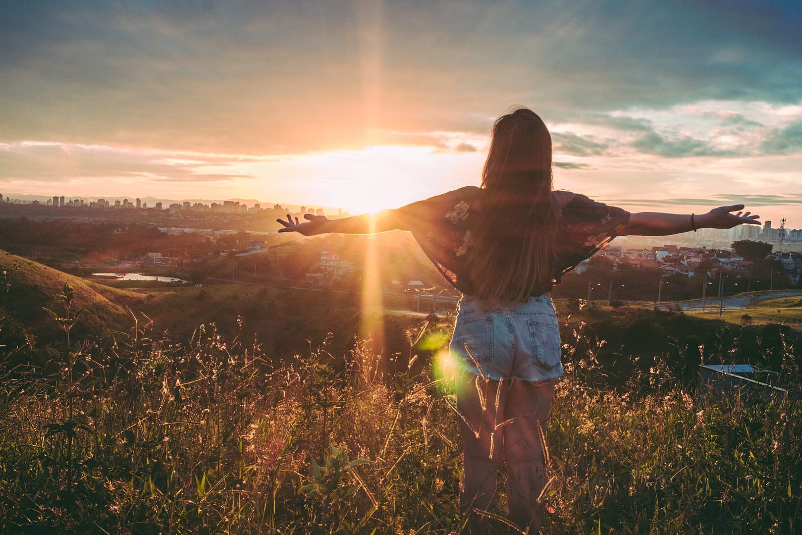 omdenken Van uitdaging naar kans &#8211; Deel 2: Omdenken &#038; focus op een ander perspectief woman stands on mountain over field under cloudy sky at 847483 scaled