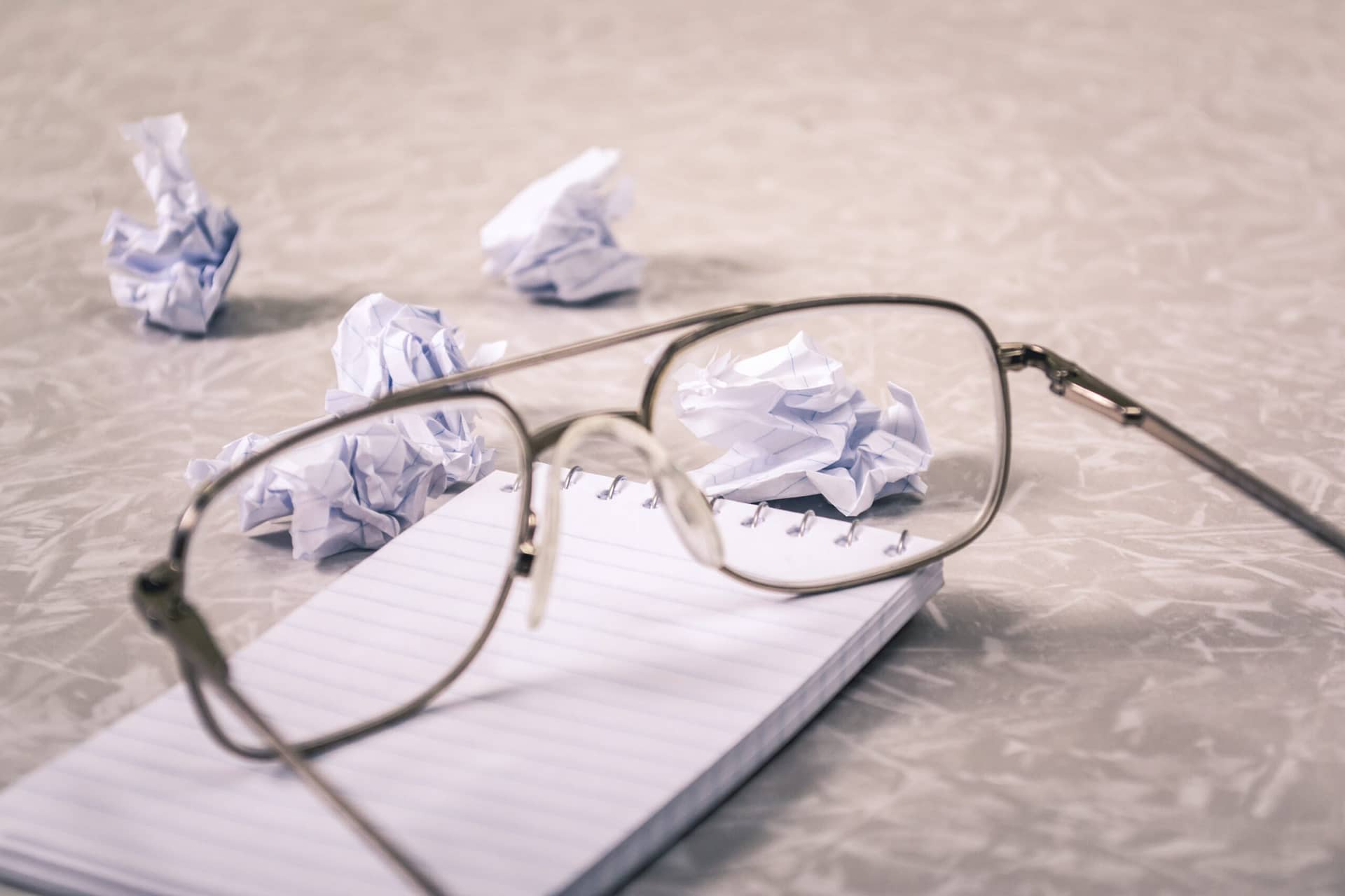 close up photography of eyeglasses near crumpled papers 963056 1 scaled